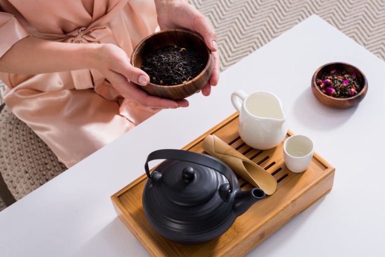 woman holding wooden bowl with tea
