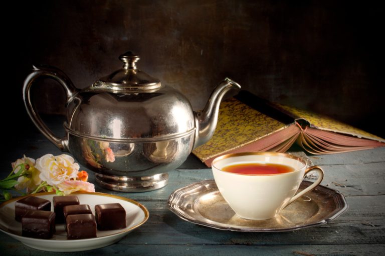 tea in a porcelain cup and silver teapot