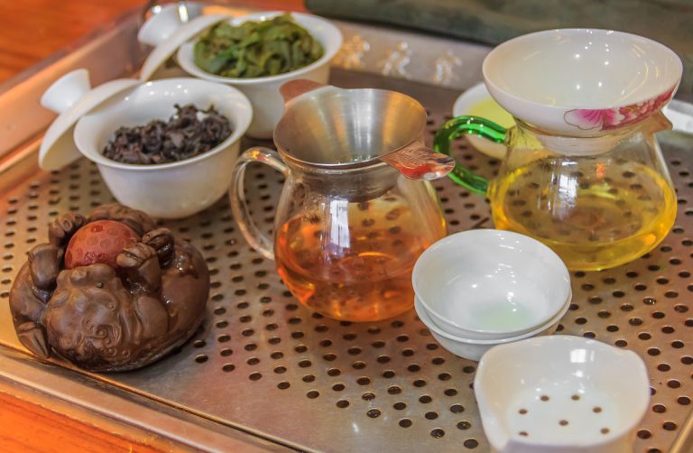 a tea pet sitting next to a tea set