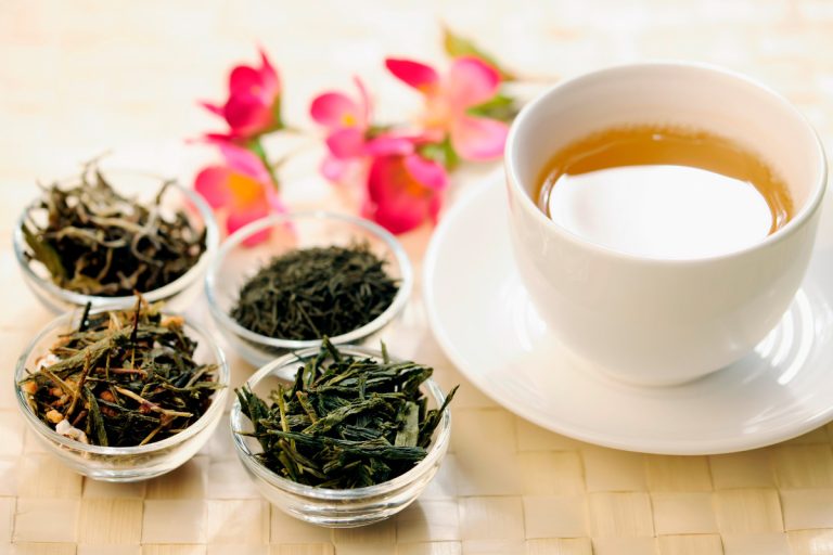 different types of green tea next to a teacup
