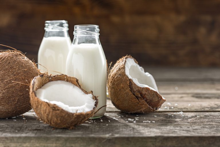 Coconut kefir in glass bottle on wooden table