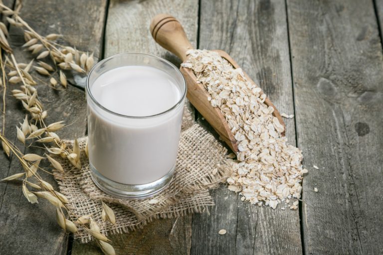 Oat milk on rustic wood background