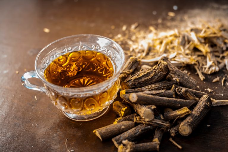 licorice tea and roots on wooden background