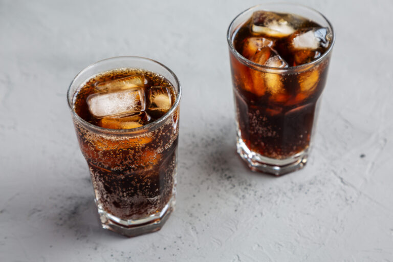 Cola soda with Ice Cubes in glass cups on a gray background