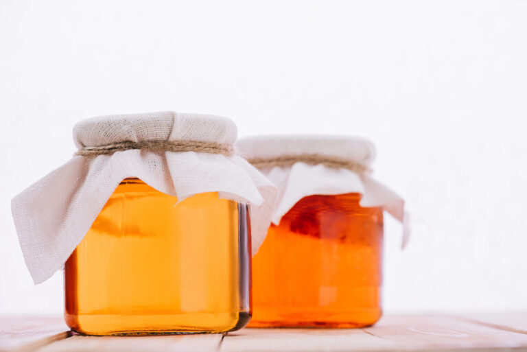 bottled natural kombucha tea in glass jars on white background