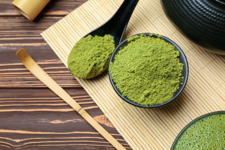 bowl and spoon with matcha on wooden table