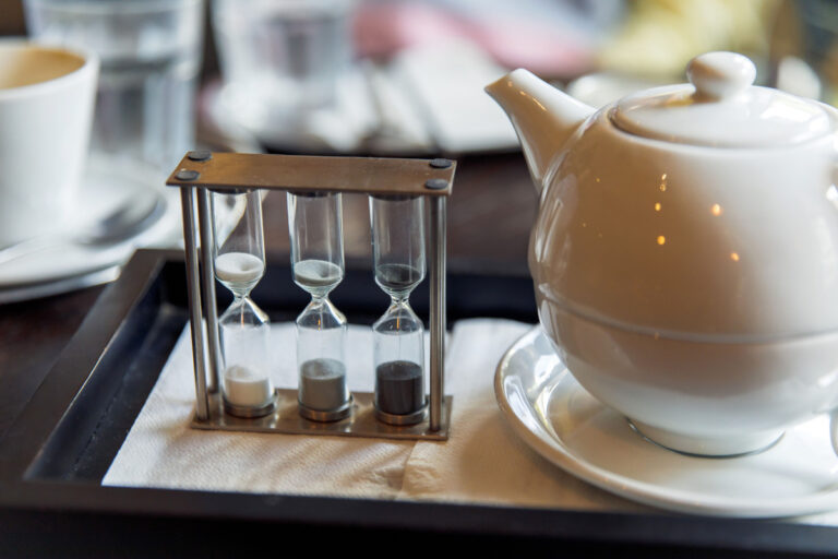 ceramic teapot and hourglass tea timer