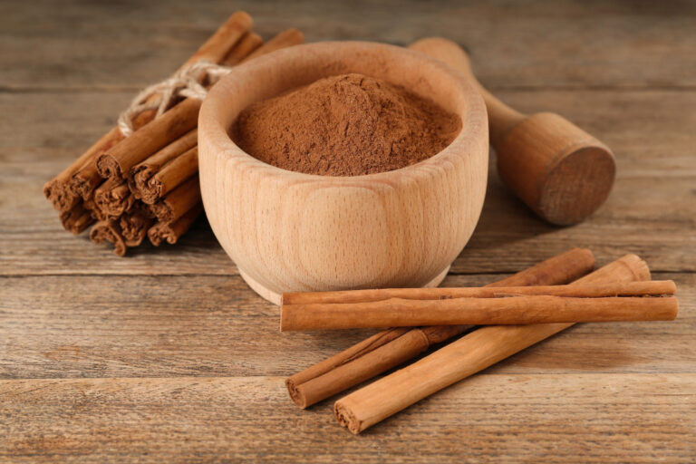 cinnamon powder and sticks with mortar and pestle